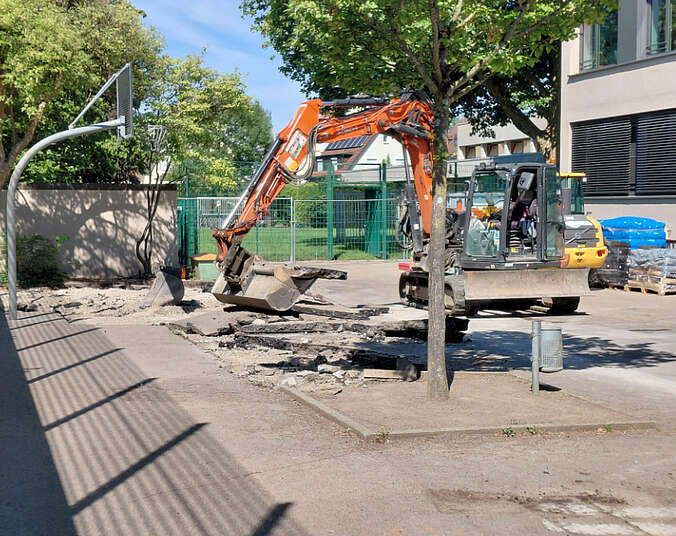 Bagger gräbt betonierten Boden auf