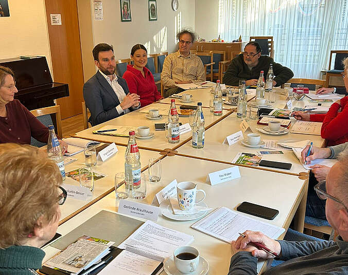 Männer und Frauen sitzen am Tisch