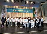 Die Ehrungsgruppe 1 wurde auf der Bühne durch den Ersten Bürgermeister Andreas Hein und Detflef Maaß, Amtsleiter Amt für Sport, Freizeit und außerschulisches Lernen, geehrt.