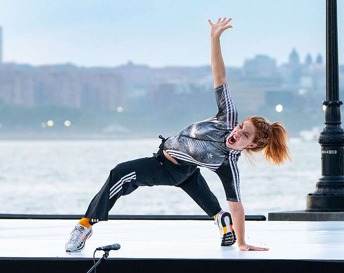 Frau macht Tanzfigur auf Boden