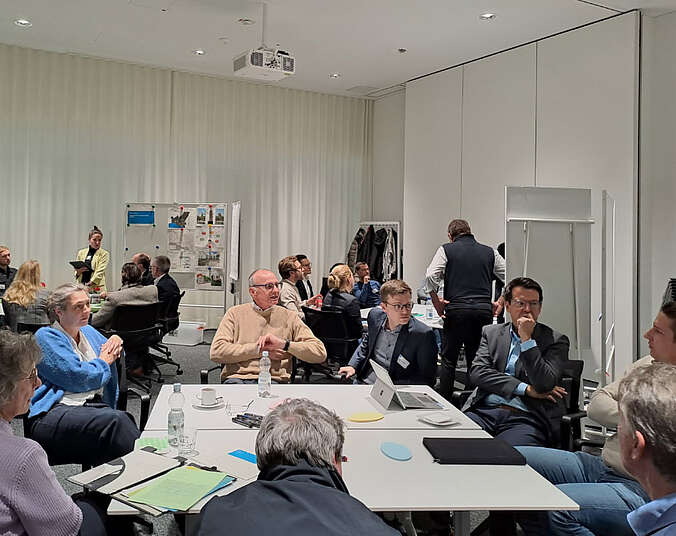 Frauen und Männer sitzen an Tischen